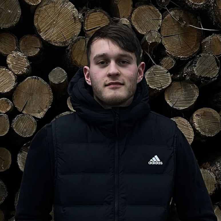 Kevin Meißner standing in front of wood